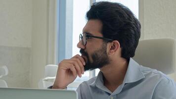 Thoughtful pensive Arabian businessman marketing manager working computer in office Indian muslim man entrepreneur thinking analyzing online business project think solve problem solution brainstorming photo