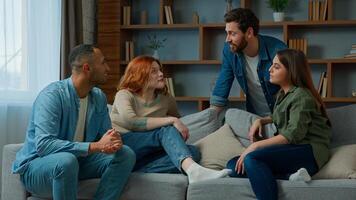 Group friends ethnic diverse women and men multiracial companions business people sit on sofa discuss plans talk indoors approve cooperation stacking hands together in pile team gesture unity teamwork photo