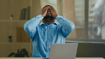 Desperate sad angry African American businessman manager entrepreneur working with laptop at office has computer problem broken device send wrong email message bad news or crash mistake error failure photo
