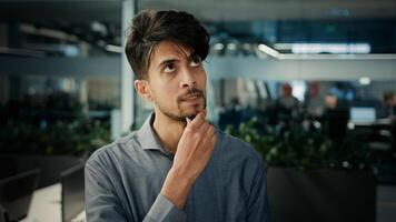 Thoughtful puzzled indian arabian man office manager smart creative concentrated worker businessman think plan ponder new idea brainstorming mind thoughts create project planning business development photo