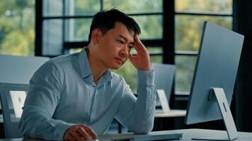 Asian businessman korean man work online at workplace difficult hard job get incorrect error in computer failure business problem. Upset anxious male disappointed about mistake bad internet in office photo