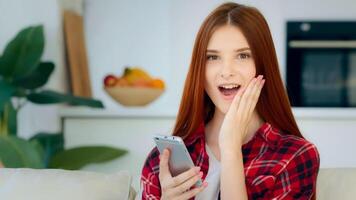 Amazed young user girl ginger student schoolgirl teenager use mobile app on phone shopping online make order win discount in internet store click on display cell option. Advertisement of modern gadget photo