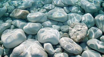 Smooth White Pebbles Submerged in Clear Blue Water on a Sunny Day photo