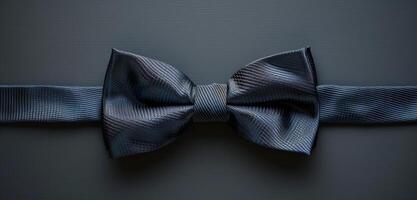 Close Up of a Dark Blue Bowtie on a Grey Surface photo