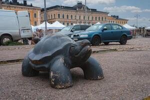 Weathered Turtle Sculpture in Helsinki Public Square with Market photo