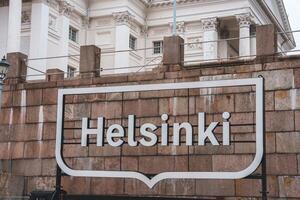 Helsinki Sign in Front of Historic Building with Classical Architecture photo