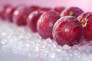 A row of glistening red plums coated with frost on a bed of ice, creating a refreshing and appetizing visual. photo