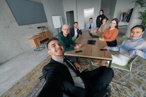 A group of business professionals taking a selfie during a break in an office meeting, capturing a moment of teamwork and collaboration in a modern workplace photo