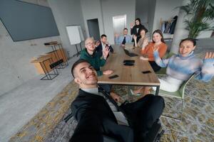 A group of business professionals taking a selfie during a break in an office meeting, capturing a moment of teamwork and collaboration in a modern workplace photo