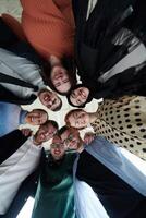 A diverse group of business professionals standing together in a powerful, united pose, captured from a low-angle perspective, exuding confidence and teamwork photo