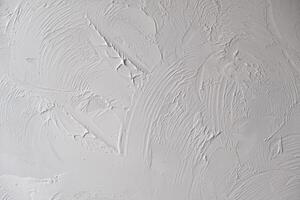 Applying decorative putty. White abstract texture of surface covered with putty photo
