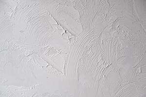 Applying decorative putty. White abstract texture of surface covered with putty photo