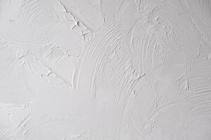 Applying decorative putty. White abstract texture of surface covered with putty photo