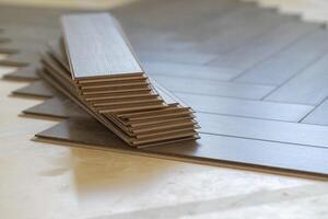 Close-up of laminate flooring installation in a modern apartment. Worker placing photo