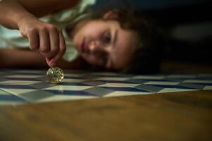 Curious child plays with a colorful bouncing ball on tiled floor photo