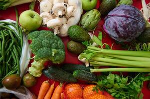 Fresh assorted vegetables on a vibrant red background photo