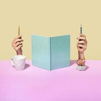Quirky office concept with upright notebook flanked by hands photo