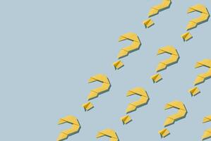 Repeat diagonal pattern of yellow paper origami question marks photo
