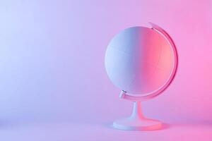 Model of a globe with blank map in pink light photo