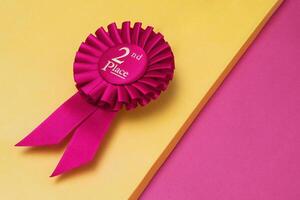 Rosette second place for the achievement and success of the winner on illuminating background photo
