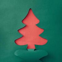 Colorful green Christmas tree paper cutout over sparkling white snow with copyspace for your holiday message or greeting in a creative handmade card photo