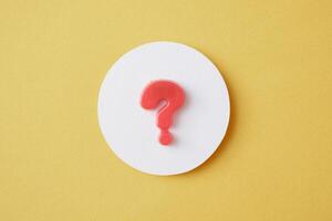 A question mark in a white circle on a yellow background Question and answer solution search concept photo