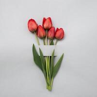 Bouquet of red or pink tulips on a grey background for an invitation to a festive event or anniversary. Minimal creative concept of spring and spring holidays. Valentine's day and mother's day. photo