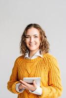 Smiling Young Professional with Digital Tablet. A cheerful businesswoman or student, holding a digital tablet. Ideal for promoting online education, e-learning platforms, and modern digital technology photo
