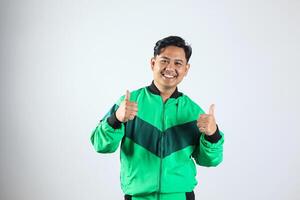 Portrait of Asian Online Courier Driver Wearing Green Jacket Showing Good Job Sign photo