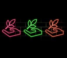 Glowing neon Hand hold a leaf of the plant icon isolated on black background. Care nature. Leaf shoots with environmental protection. vector