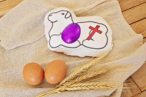 Easter lamb cake with symbolic cross and eggs on burlap cloth photo