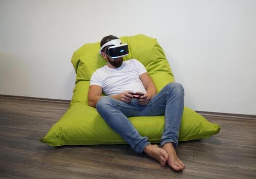 Man Using Virtual Reality in a Relaxed Bean Bag Gaming Setup photo