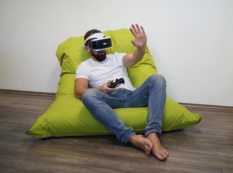 Man Using Virtual Reality in a Relaxed Bean Bag Gaming Setup photo