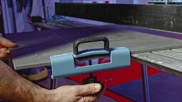 Close-up of man cutting tile products on machine. Creative. Machine with fastening for cutting tiles. Carpenter with measurements divides board or tile video