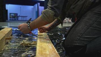 Close up of worker using tools for making holes in wooden beam. Media. Carpentry works for making decorations. video