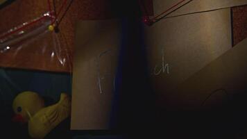 Lantern illuminates notes on board. Stock footage. Notes with words on blackboard in night office. Quest with rebus on notes with strings video