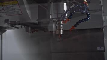 Automated rotating drill for metal. Media. Machine with drill moving in production. Robotic machine with drill cutting metal video