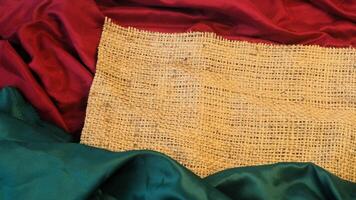 A rustic vintage burlap featuring green and red plain fabric, copy space for minimalist christmas greeting design textured background photo