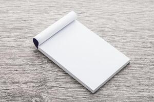 Blank notepad on wooden table top view photo