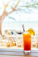 A drink with a slice of lemon and a straw photo