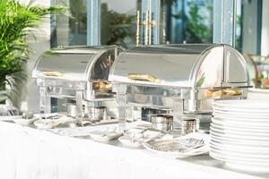 Buffet with silver trays and plates on a table photo