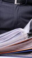 vertical Busy office worker searches through a stack of files, highlighting the chaos of business paperwork. The image captures the stress of deadlines and the need for organization video