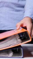 vertical men stack binders with documents on the desk. Concept of archive of documents. Worker organizes archive folders on a desk in a busy office, creating an efficient workspace video