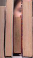 vertical little girl takes a book from a bookshelf. girl takes a book in the library. full bookshelf. girl chose a book on a bookshelf video