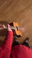 vertical pov first person view man holds an acoustic guitar in his hand. A man is getting ready to play the guitar. showing passion and creativity in a cozy indoor setting, inspiring viewers video
