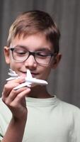 vertical boy playing with airplane model. Boy dreams of becoming a pilot. Child dreams of flying on an airplane. Dreams of traveling on an airplane. Child's dream concept video