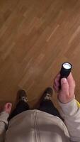 vertical pov First person view Man explores a dark room with a flashlight, revealing a stunning parquet floor, casting shadows and creating suspense. Man turns on flashlight in room video