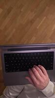 vertical POV first person view Man standing holding laptop on his hand and typing text, messages. Online work. Online communication. Internet communication. Freelancer work video