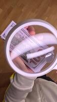 vertical pov First person view Hands inspecting 100 usd bill with magnifying glass on wooden floor, emphasizing authenticity and scrutiny in finance video