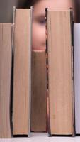 vertical little girl putting a book on a bookshelf. girl returning a book to the library. full bookshelf. girl arranging books on a shelf. little curious girl looking through a wall of books video
